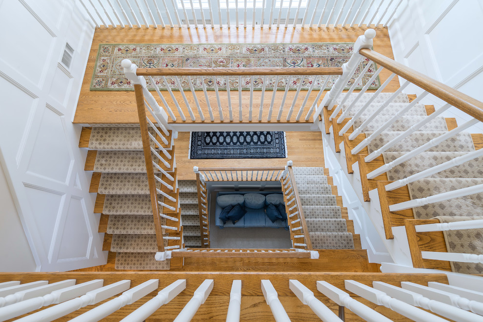 Inspiration pour un très grand escalier traditionnel en U avec des marches en bois, des contremarches en bois et un garde-corps en bois.