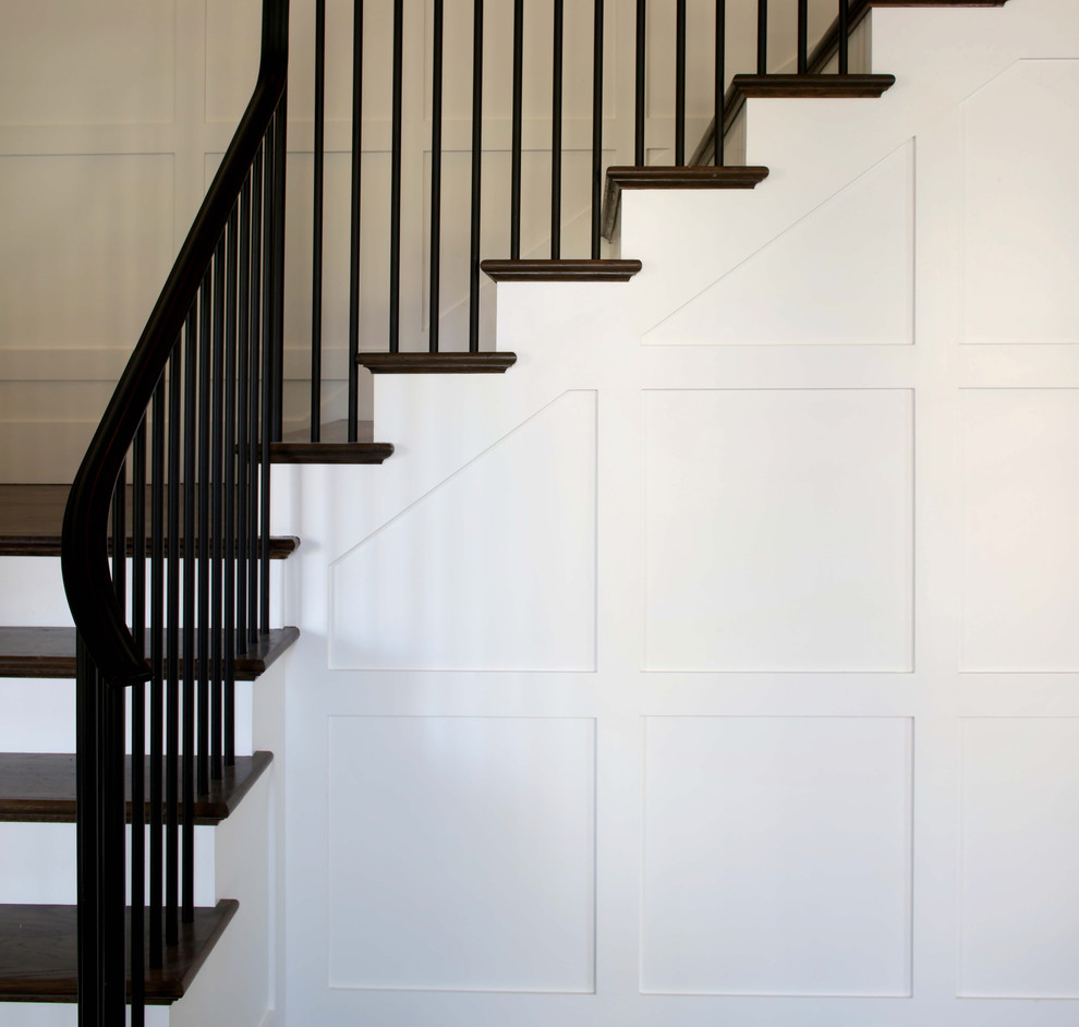 Diseño de escalera en L clásica renovada grande con escalones de madera, contrahuellas de madera pintada y barandilla de metal