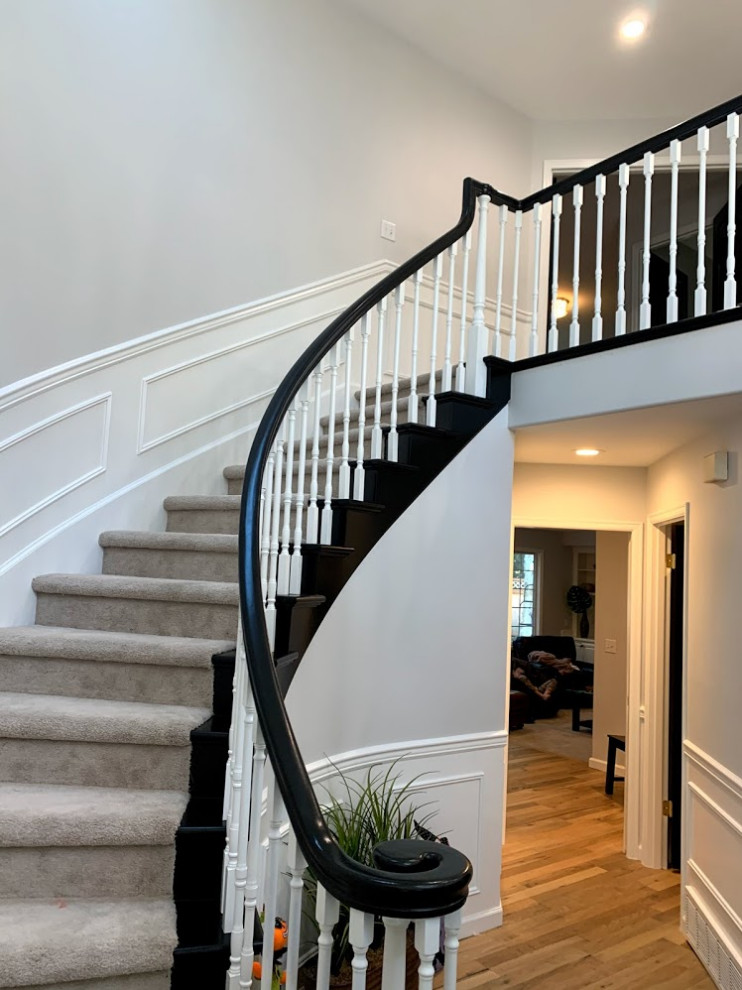 Medium sized traditional carpeted curved wood railing staircase in Seattle with carpeted risers and wainscoting.