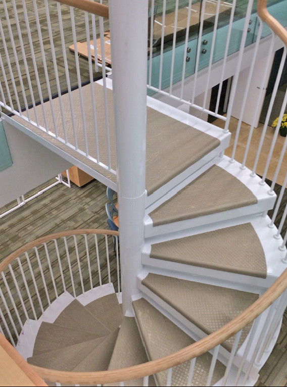 Medium sized traditional metal spiral wood railing staircase in DC Metro with metal risers.