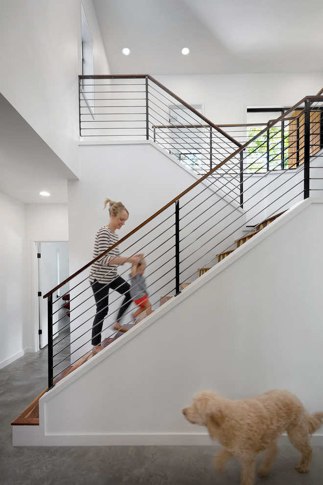 Diseño de escalera en U contemporánea con escalones de madera y barandilla de cable