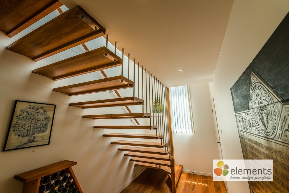 Ejemplo de escalera recta contemporánea pequeña sin contrahuella con escalones de madera y barandilla de metal