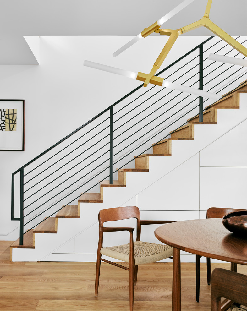 Foto de escalera recta actual con escalones de madera, contrahuellas de madera y barandilla de metal