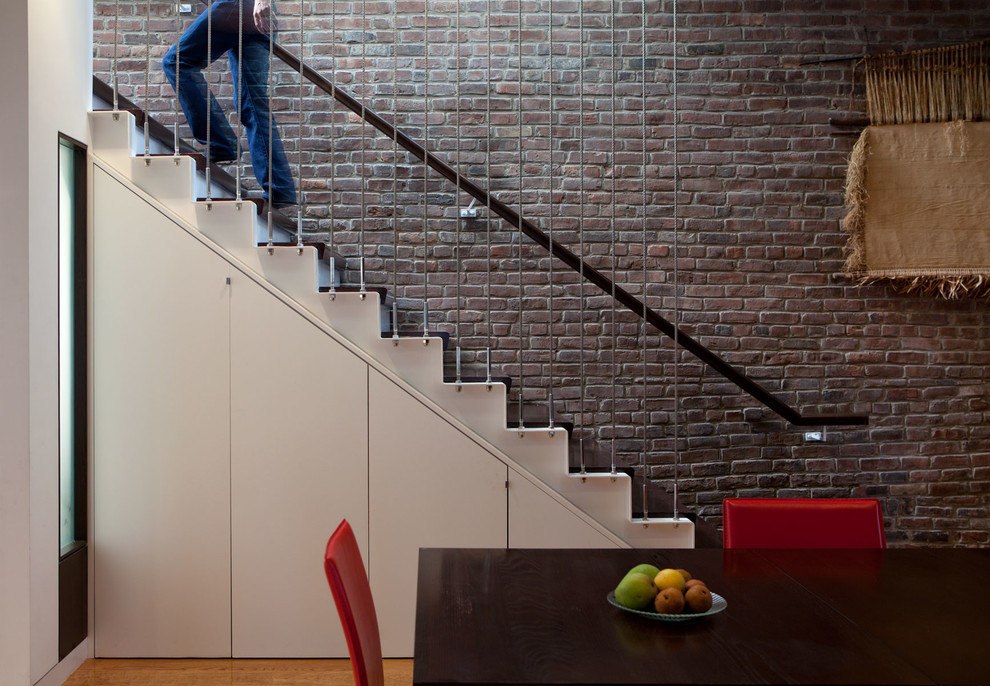 Стильный дизайн: лестница в современном стиле с деревянными ступенями и кладовкой или шкафом под ней - последний тренд