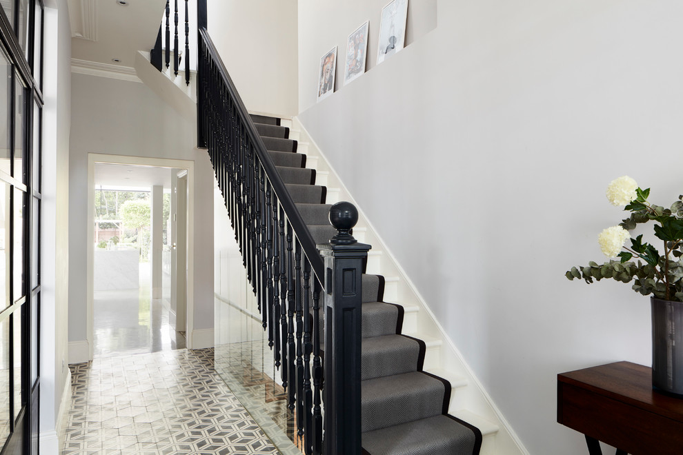 На фото: угловая лестница в классическом стиле с крашенными деревянными ступенями с