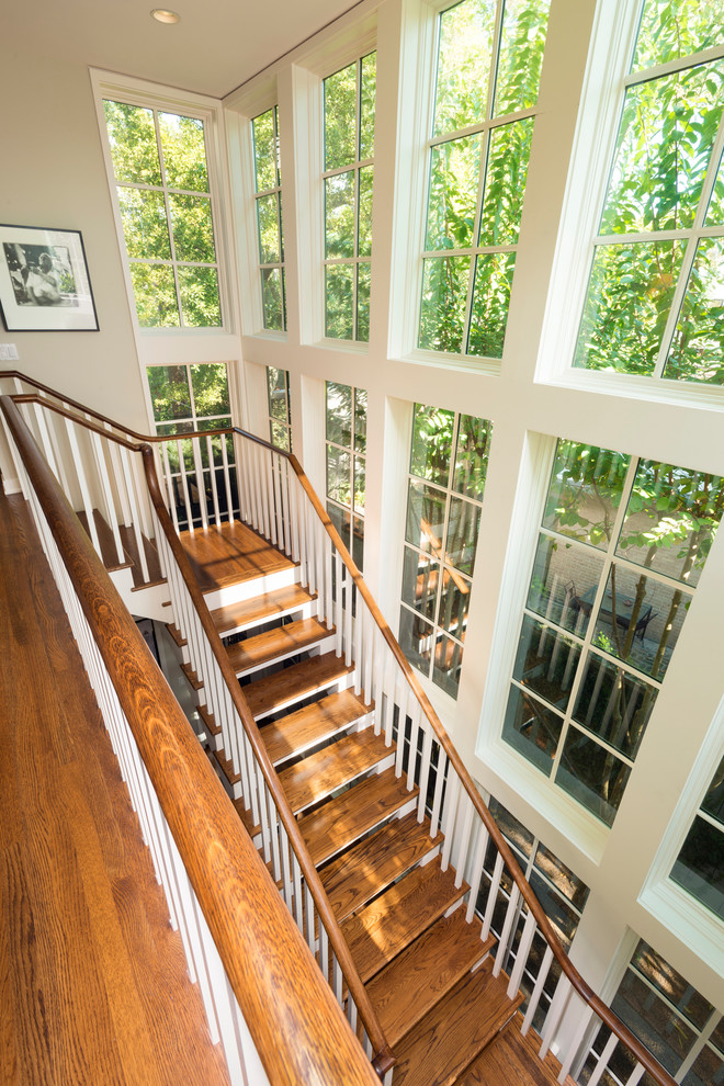Ejemplo de escalera en L de estilo americano grande con escalones de madera y contrahuellas de madera pintada