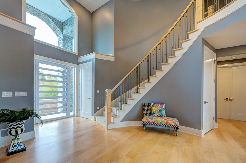 Источник вдохновения для домашнего уюта: большая изогнутая лестница в стиле модернизм с ступенями с ковровым покрытием, ковровыми подступенками и деревянными перилами