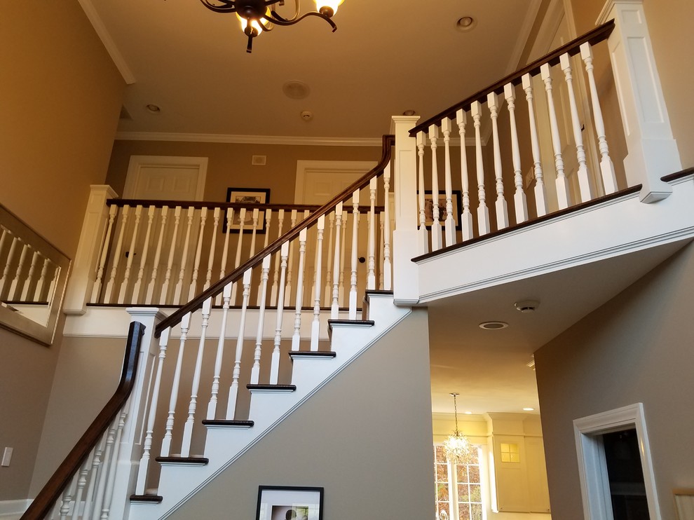 Идея дизайна: угловая лестница среднего размера в классическом стиле с ступенями с ковровым покрытием, ковровыми подступенками и деревянными перилами
