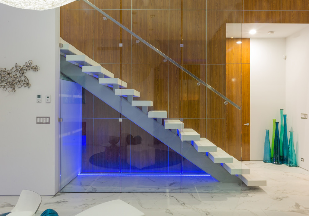 Идея дизайна: большая прямая лестница в стиле модернизм с бетонными ступенями и стеклянными перилами без подступенок