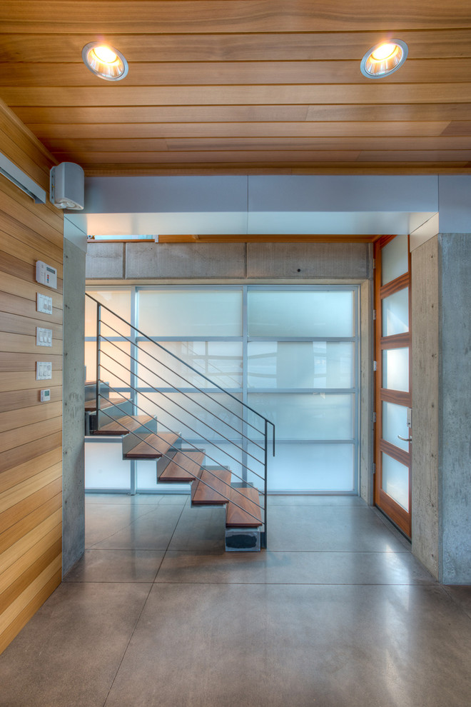 Imagen de escalera recta moderna pequeña con escalones de madera, contrahuellas de metal y barandilla de metal