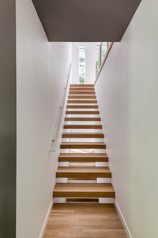 На фото: лестница в стиле модернизм с деревянными ступенями без подступенок с
