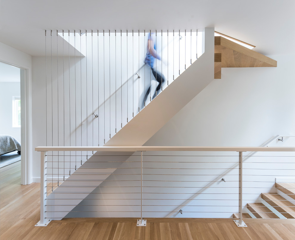 Идея дизайна: прямая лестница в стиле модернизм с деревянными ступенями и перилами из тросов без подступенок