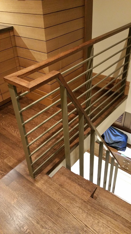 Cette image montre un grand escalier courbe minimaliste avec des marches en bois et des contremarches en bois.