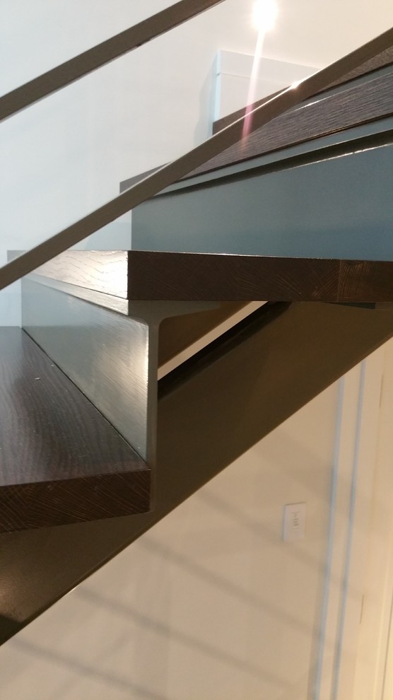 Imagen de escalera curva minimalista grande con escalones de madera y contrahuellas de madera
