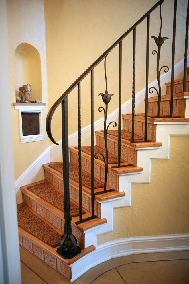 Идея дизайна: большая угловая лестница в средиземноморском стиле с ступенями с ковровым покрытием и подступенками из плитки