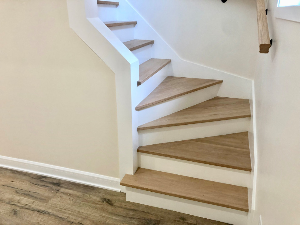 Foto de escalera en L minimalista de tamaño medio con escalones de madera, contrahuellas de madera y barandilla de madera