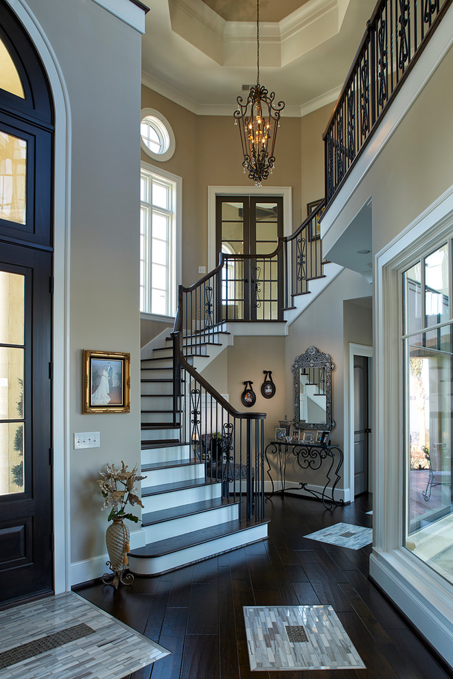 Пример оригинального дизайна: большая п-образная лестница в классическом стиле с деревянными ступенями, крашенными деревянными подступенками и перилами из смешанных материалов