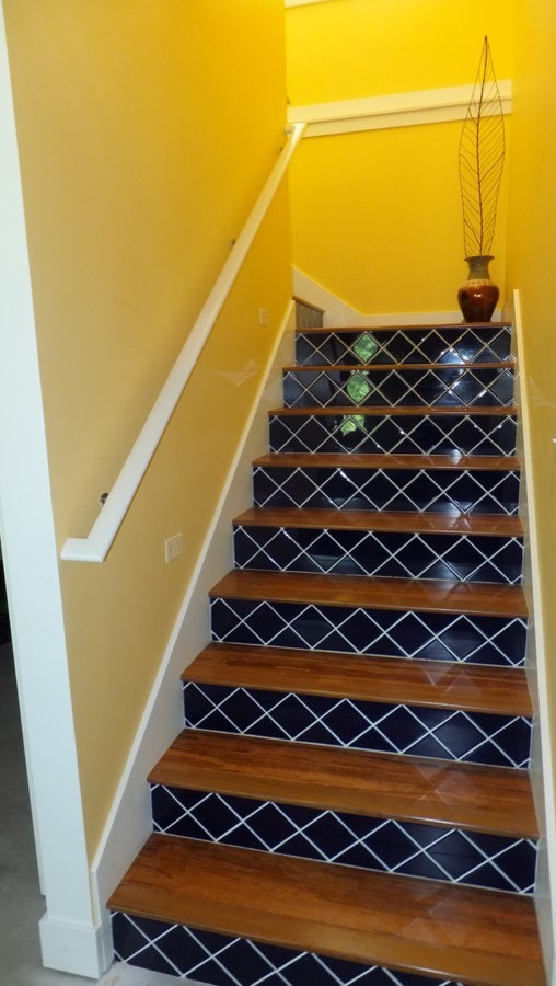 グランドラピッズにある中くらいなサンタフェスタイルのおしゃれなかね折れ階段 (タイルの蹴込み板) の写真