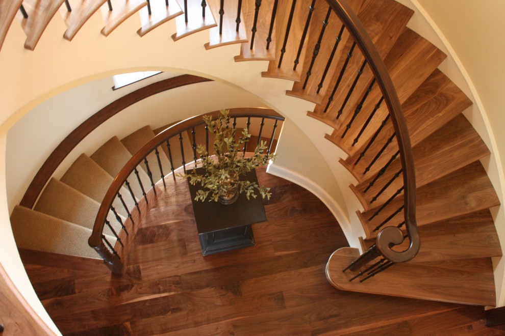 Diseño de escalera curva mediterránea grande con escalones de madera y contrahuellas de madera