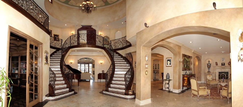Expansive mediterranean wood curved metal railing staircase in Los Angeles with tiled risers.