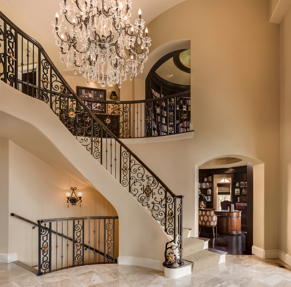 Staircase - huge mediterranean wooden curved staircase idea in Kansas City with painted risers