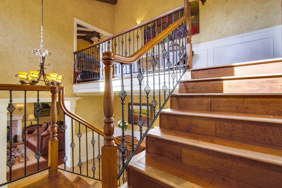 This is an example of a medium sized mediterranean l-shaped staircase in Los Angeles with wood risers.