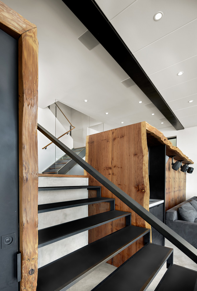На фото: прямая лестница среднего размера в стиле модернизм с металлическими ступенями и металлическими перилами без подступенок