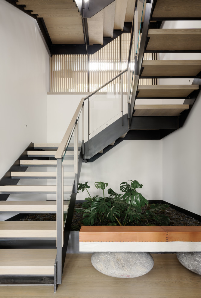 Design ideas for a modern wood u-shaped mixed railing staircase in San Francisco with open risers.