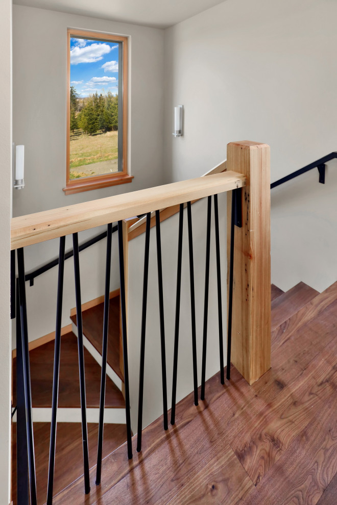 Foto de escalera en U rústica de tamaño medio con escalones de madera, contrahuellas de madera y barandilla de metal