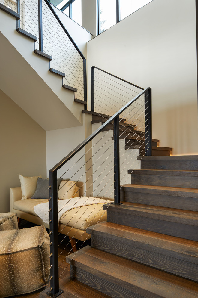 Medium sized rustic wood l-shaped wire cable railing staircase in Denver with wood risers.