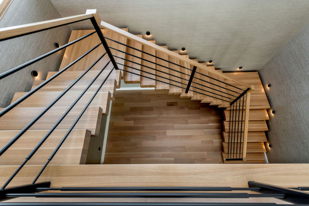 На фото: п-образная деревянная лестница в стиле модернизм с деревянными ступенями и перилами из смешанных материалов с