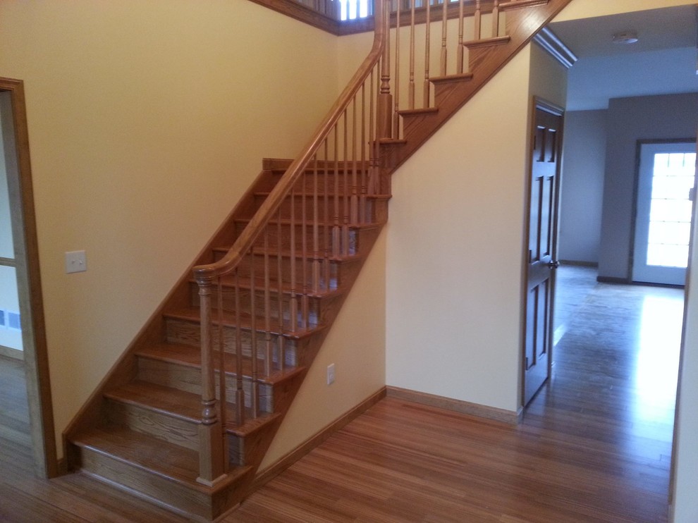 Foto de escalera en L clásica de tamaño medio con escalones de madera, contrahuellas de madera y barandilla de madera