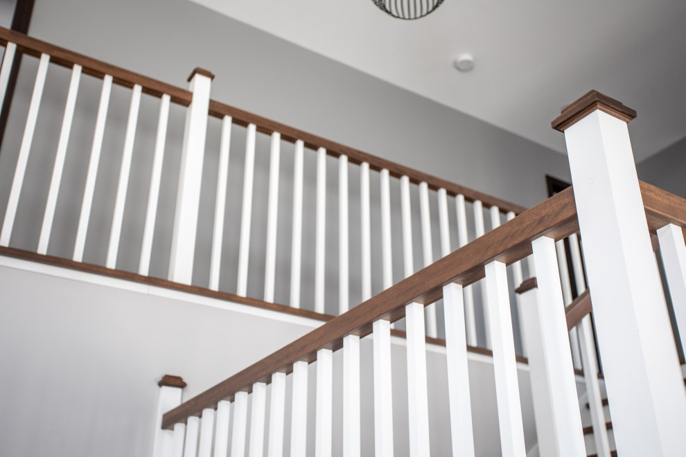 Imagen de escalera en U de estilo de casa de campo con escalones de madera, contrahuellas de madera y barandilla de madera