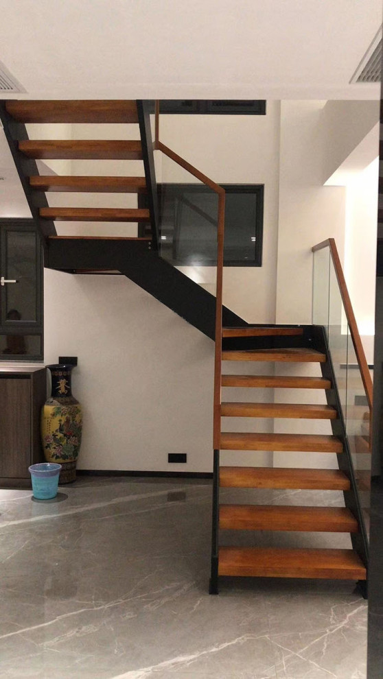 Idée de décoration pour un escalier sans contremarche minimaliste en U de taille moyenne avec des marches en bois et un garde-corps en verre.