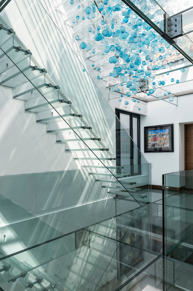 Ejemplo de escalera suspendida actual grande con escalones de vidrio y contrahuellas de vidrio