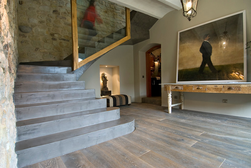 This is an example of a medium sized rustic concrete u-shaped staircase in Barcelona with concrete risers.