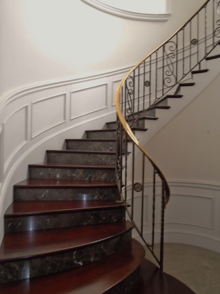 Staircase - mid-sized traditional wooden curved staircase idea in Miami with tile risers