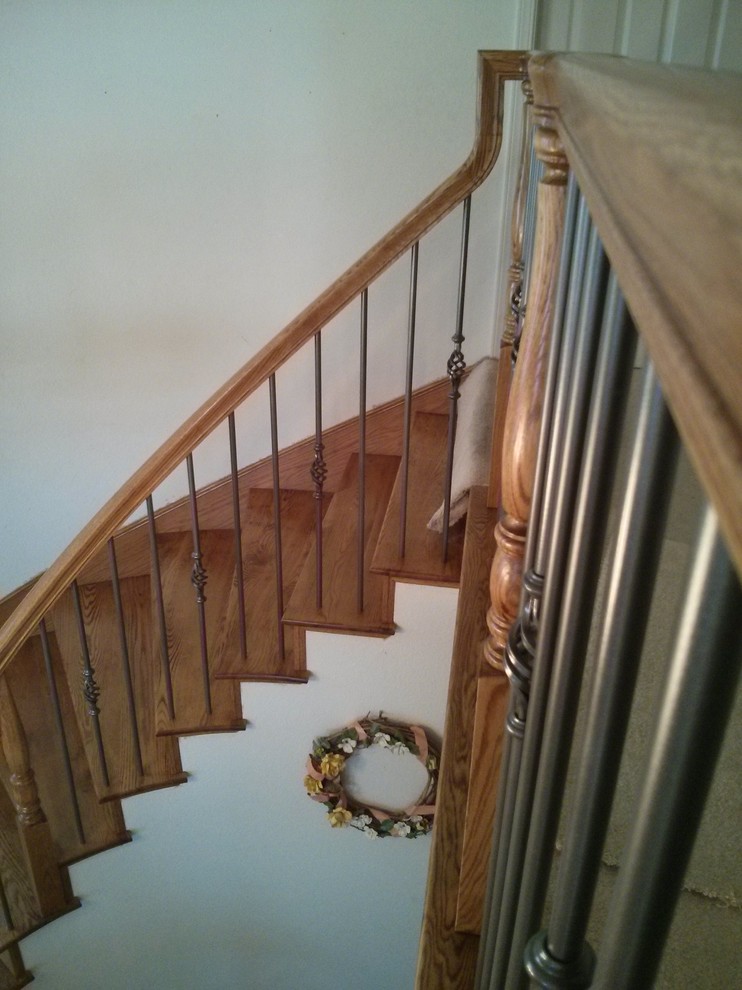 Réalisation d'un escalier courbe design de taille moyenne avec des marches en bois et des contremarches en bois.
