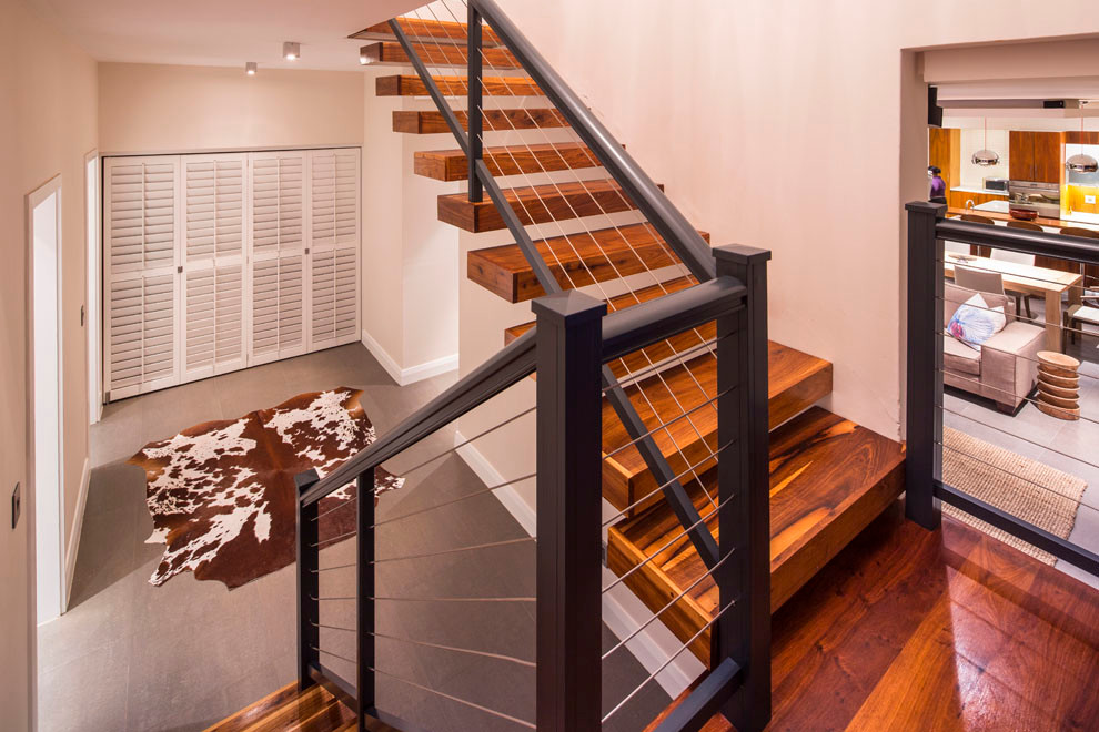 Contemporary wood floating wire cable railing staircase in Other.
