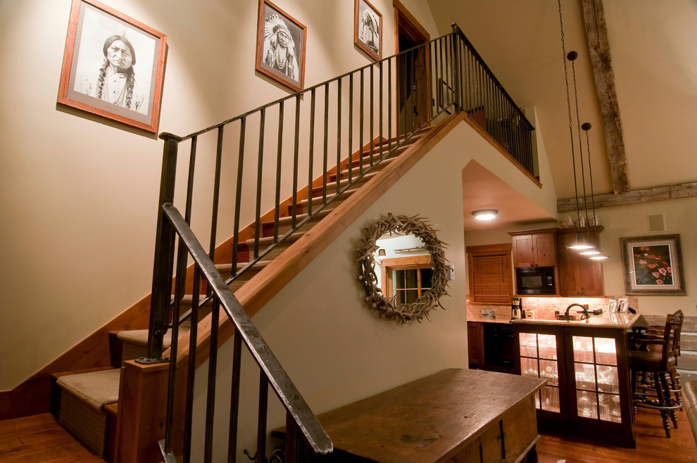 Foto de escalera en L rústica de tamaño medio con escalones de madera y contrahuellas enmoquetadas