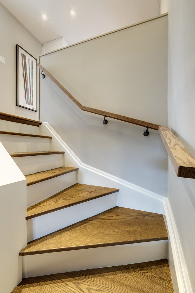 Свежая идея для дизайна: угловая лестница среднего размера в стиле неоклассика (современная классика) с деревянными ступенями и крашенными деревянными подступенками - отличное фото интерьера