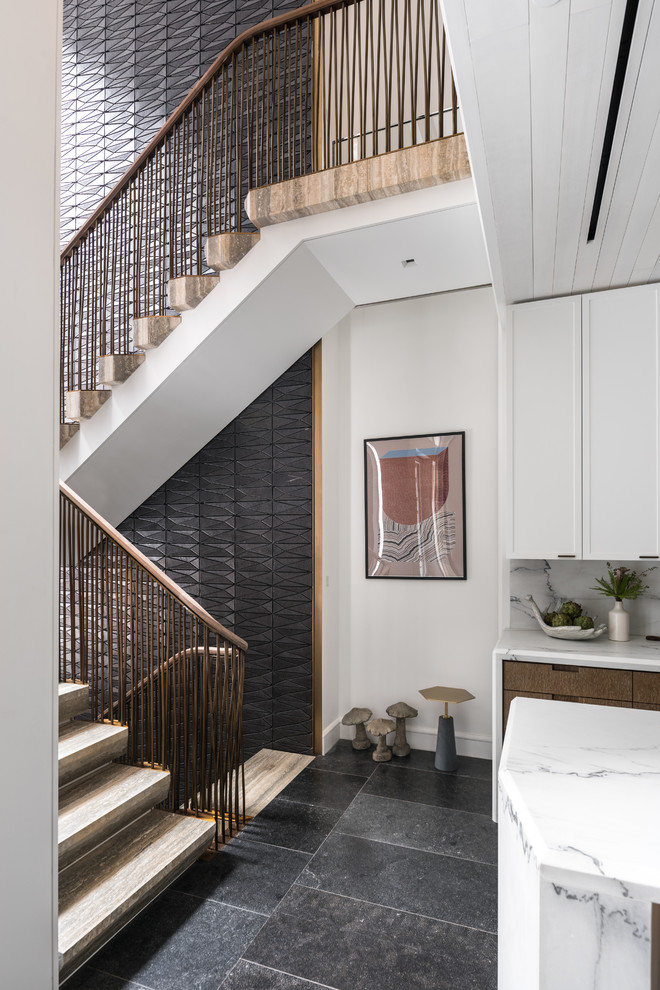 Photo of a large modern u-shaped mixed railing staircase in New York with travertine treads and open risers.