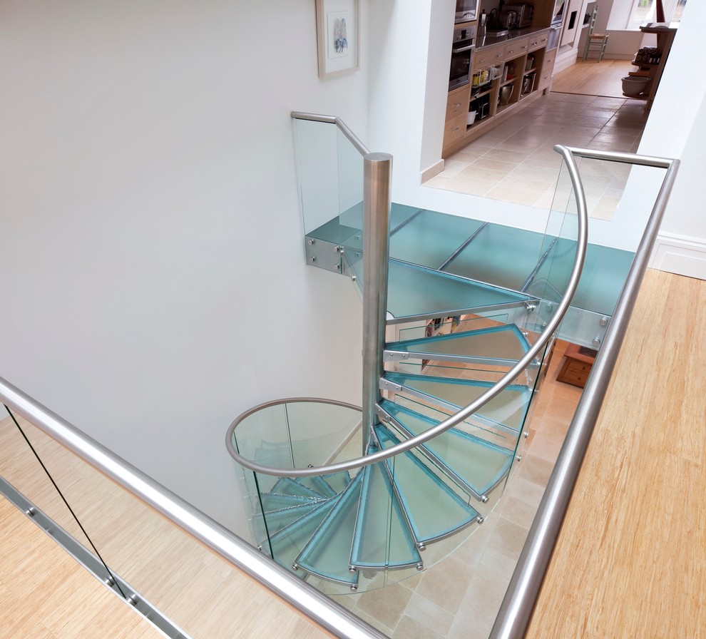Стильный дизайн: винтовая лестница в стиле модернизм с стеклянными ступенями и стеклянными подступенками - последний тренд