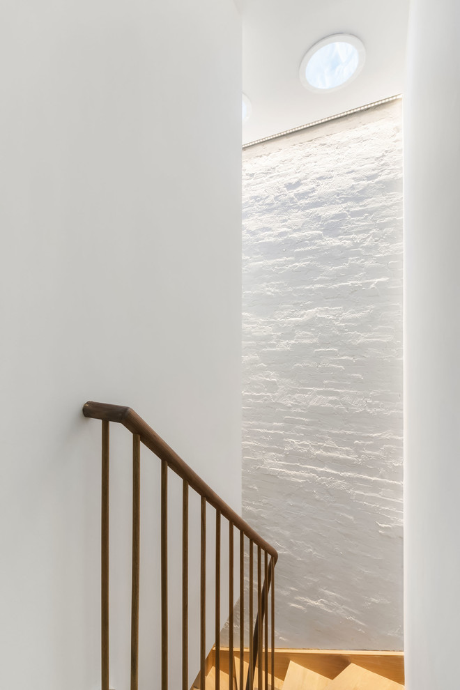 Стильный дизайн: изогнутая деревянная лестница среднего размера в стиле модернизм с деревянными ступенями и деревянными перилами - последний тренд