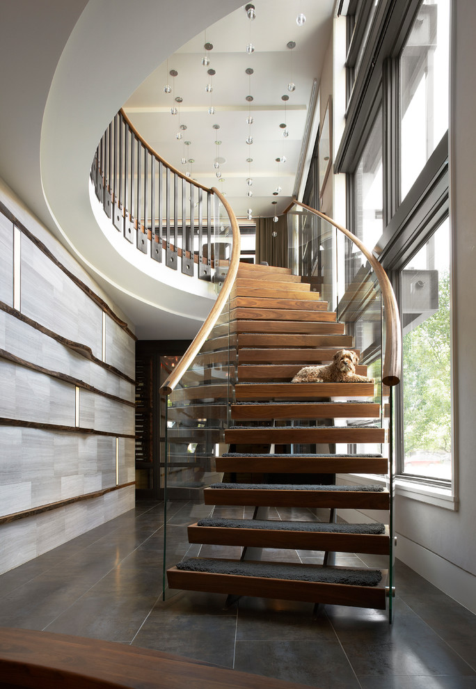 Inspiration for a contemporary wood curved staircase in Chicago with open risers and feature lighting.