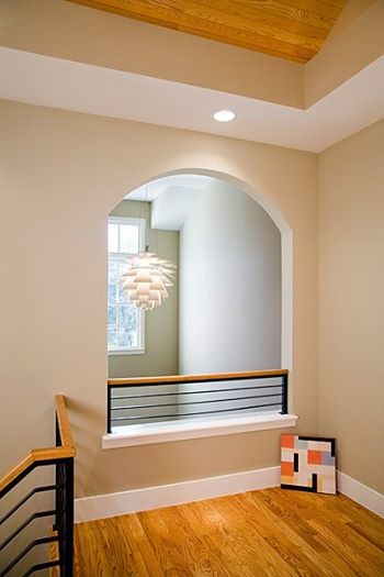 Imagen de escalera en L minimalista de tamaño medio con escalones de madera, contrahuellas de madera y barandilla de metal