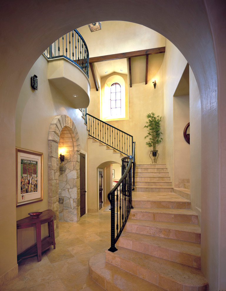 На фото: лестница в средиземноморском стиле с ступенями из травертина и подступенками из травертина