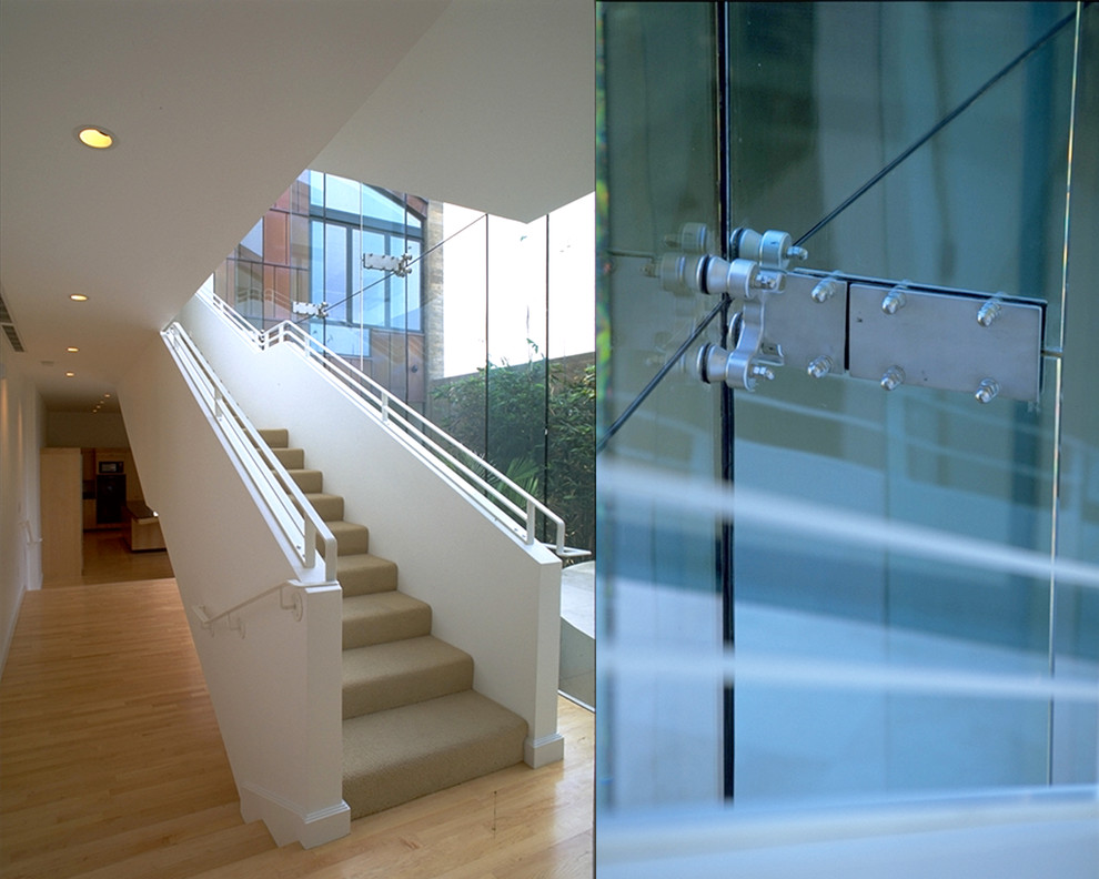 Aménagement d'un grand escalier droit moderne avec des marches en moquette, des contremarches en moquette, un garde-corps en métal et éclairage.