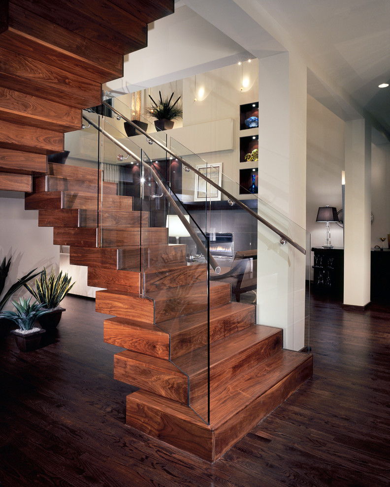 Cette photo montre un escalier flottant tendance de taille moyenne avec des marches en bois, des contremarches en bois, un garde-corps en verre et éclairage.