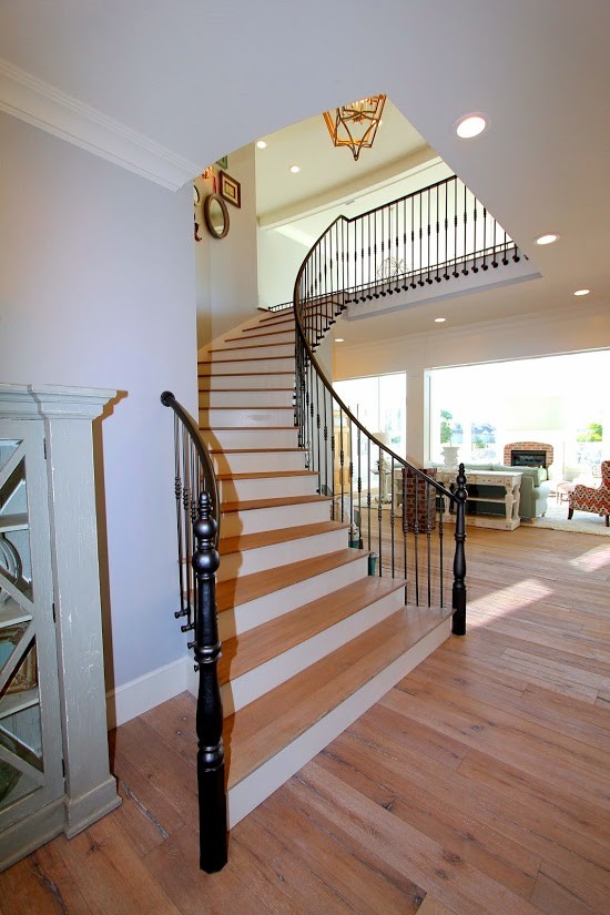 Foto de escalera curva de estilo de casa de campo extra grande con escalones de madera y contrahuellas de madera